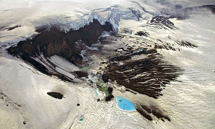 Luftaufnahme des Vukans Grimsvötn auf Island. Er gehört zu den drei aktivsten Vulkanen Islands. Am Rand sind die blauen Gletscher- und Schmelzwasserseen zu erkennen.