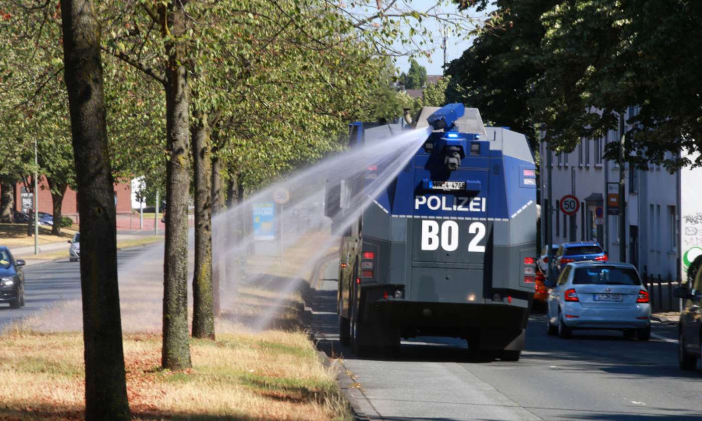 Bewässerung von Stadtbäumen durch einen Wasserwerfer der Polizei in Bochum