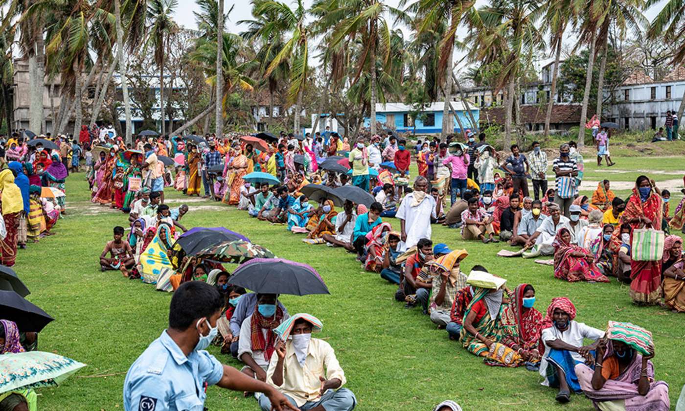 Menschen sitzen hintereinander auf der Wiese