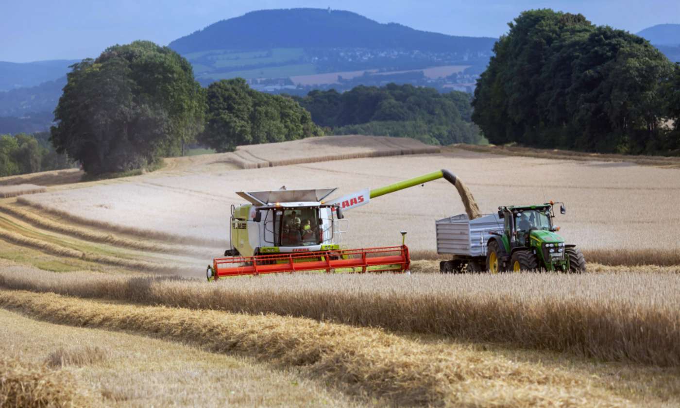 Mähdrescher und Traktor mit Anhänger