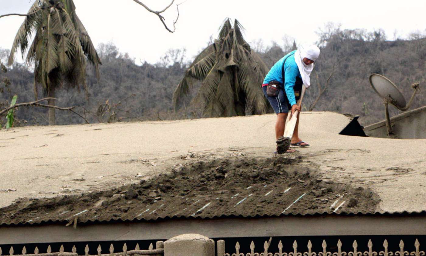 Mann fegt Asche von Hausdach
