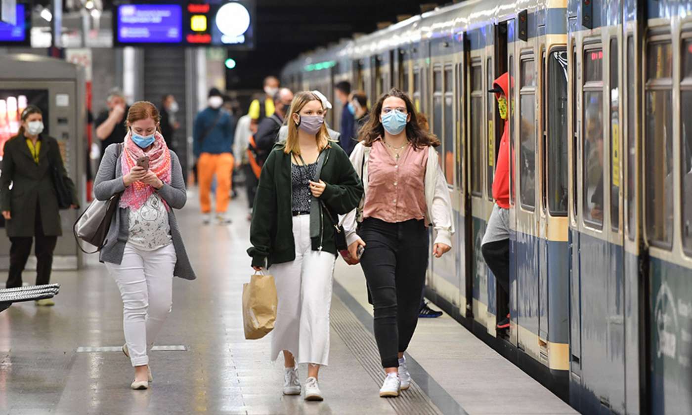 Fahrgäste auf dem Bahnsteig mit Mundschutz